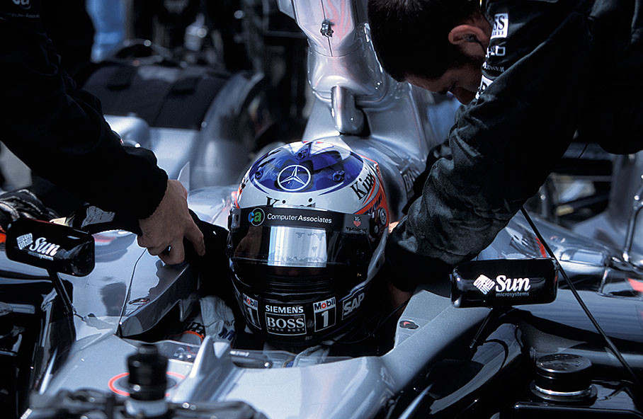 Kimi Raikkonen in McLaren Mercedes pits is being strapped into his car seat