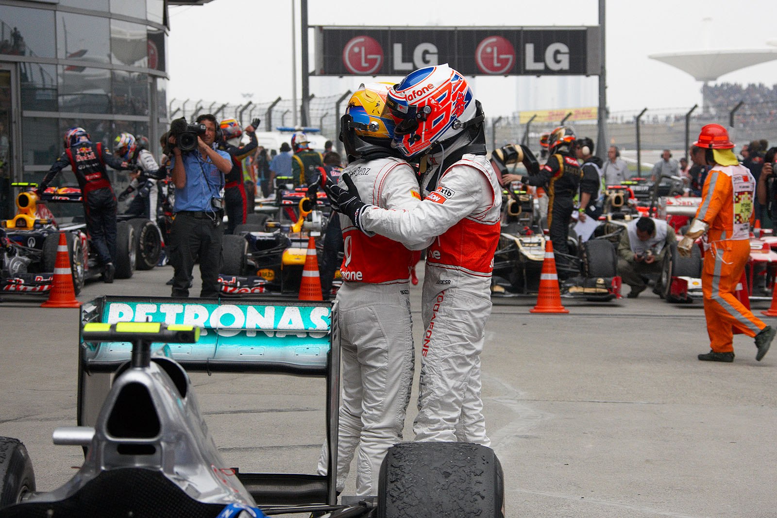 McLaren team mates Hamilton and Button caress each other in parc ferme after finishing 2-3 behind Rosberg