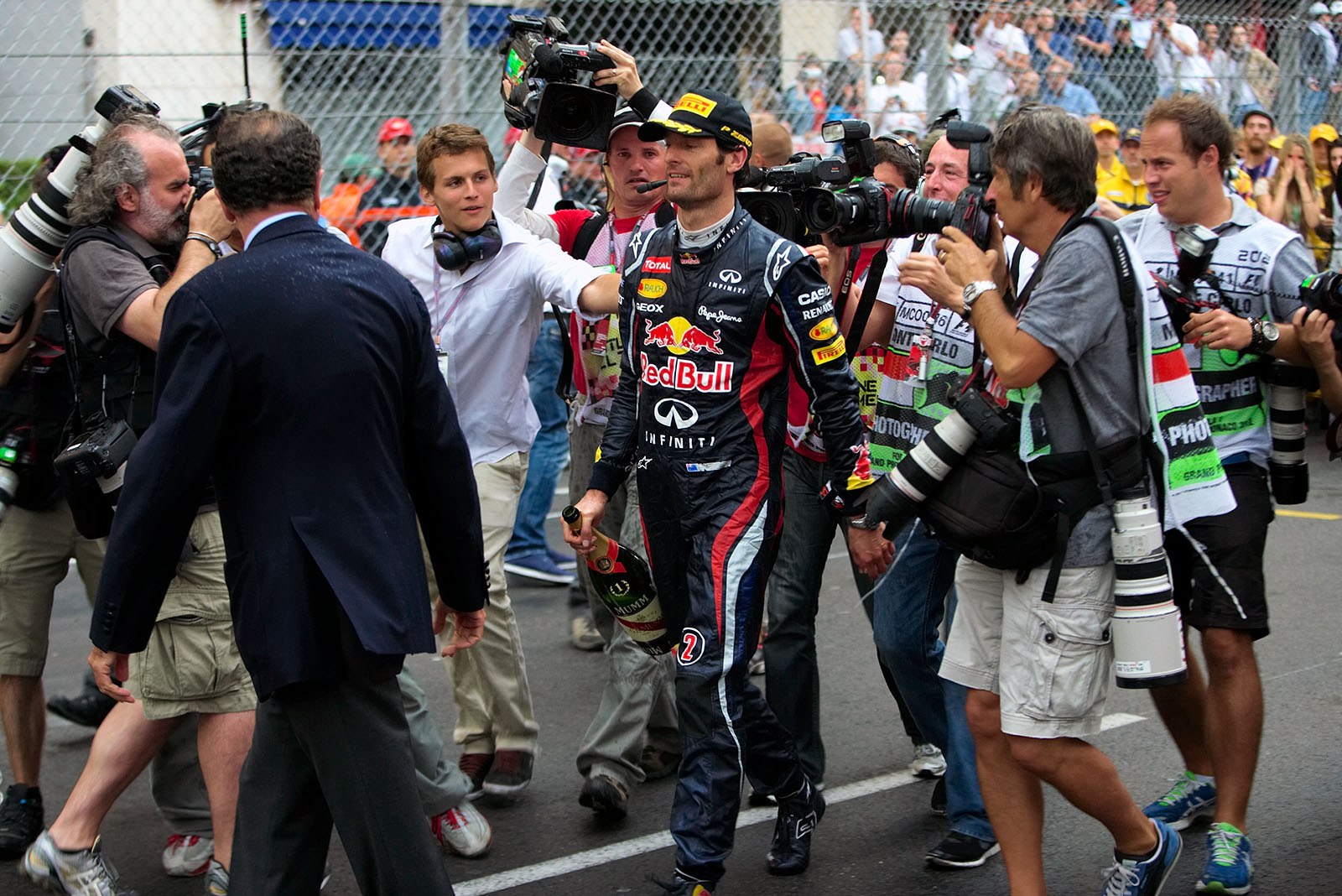 Race winner Mark Webber walks towards his car with the champagne bottle after the podium ceremony