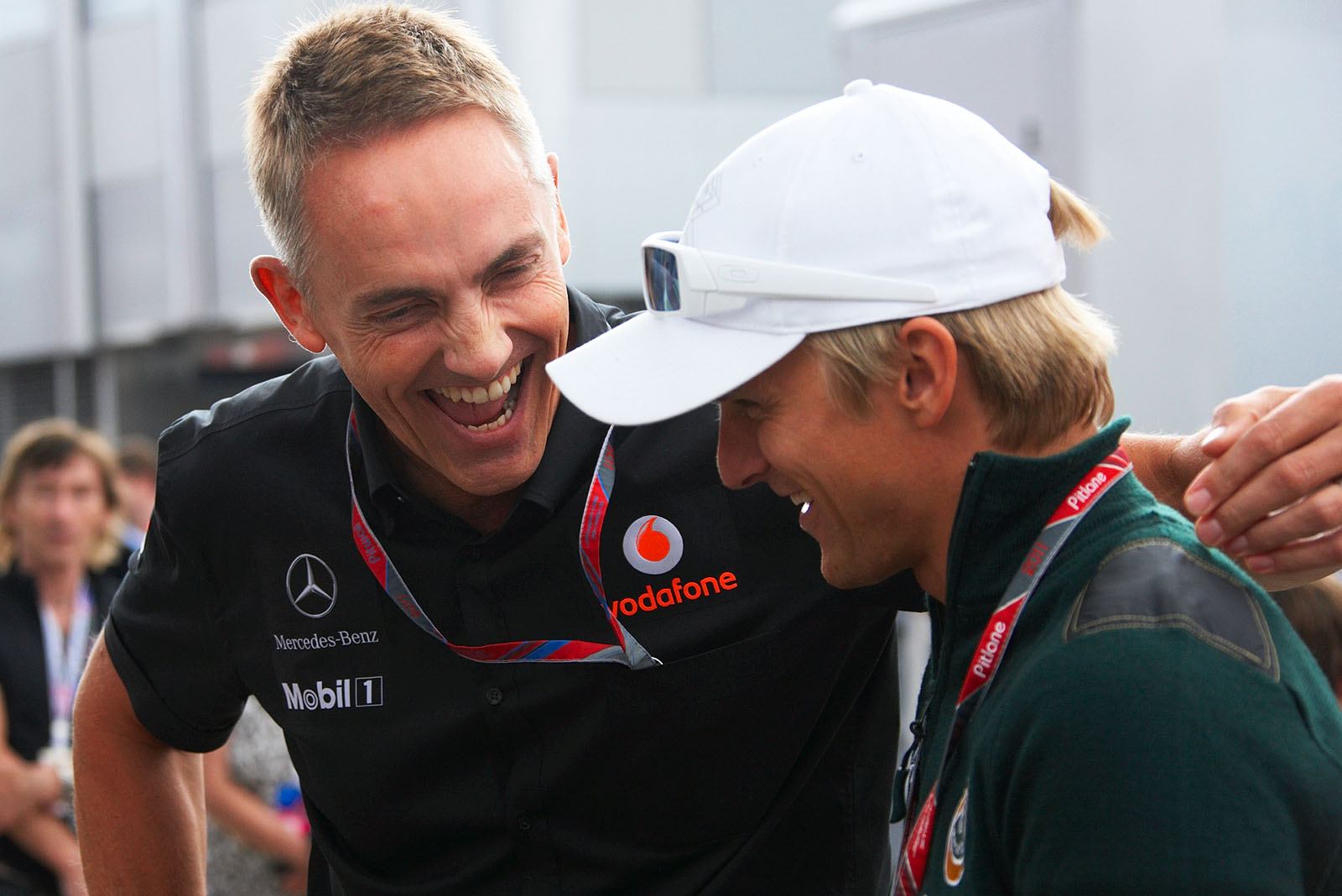 McLaren team boss Martin Whitmarsh and Heikki Kovalainen of Lotus have fun in the paddock after the race
