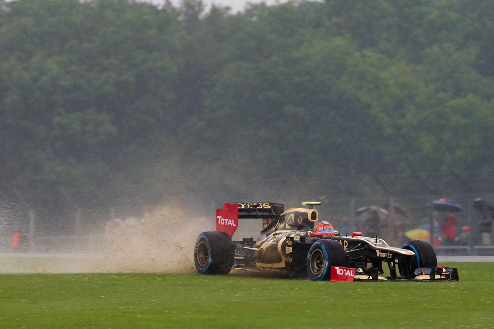 Romain Grosjean, Lotus F1 team, surfs through the puddles abroad the racing line