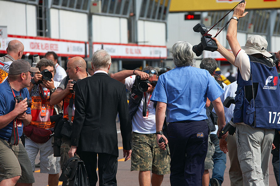 FIA president Max Mosley and FIA director of communications Richard Woods walk through Monaco pitlane and a swarm of snappers chasing them