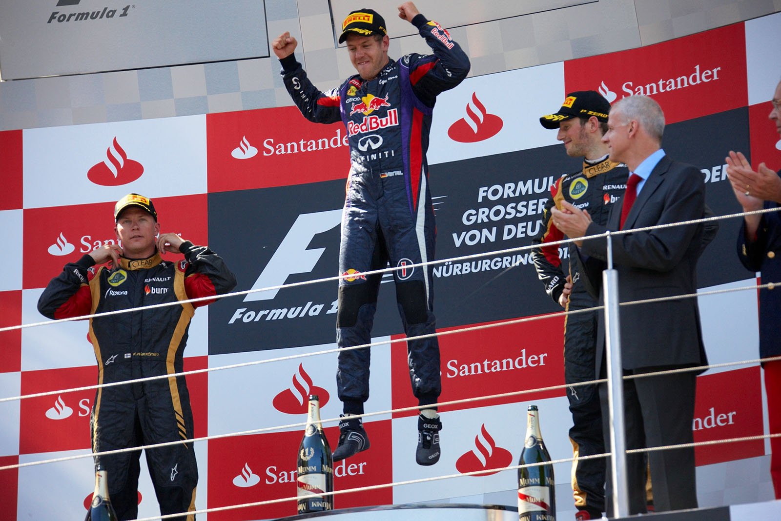 Race winner Sebastian Vettel of Red Bull Racing jumps at the rostrum, celebrating a victory at his home Grand Prix for the first time