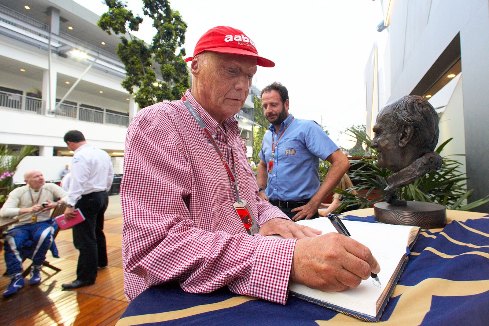 Niki Lauda signs the condolence book at the Sid Watkins memorial, the 'Prof' died a week earlier
