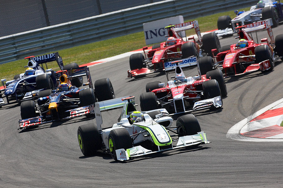 Jenson Button of Brawn GP takes the first corner as still second positioned behind Vettel who already passed turn 1