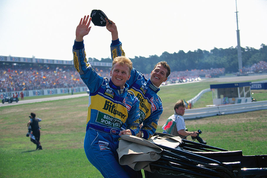 Benetton drivers Johnny Herbert and Michael Schumacher wave to the fans during drivers parade