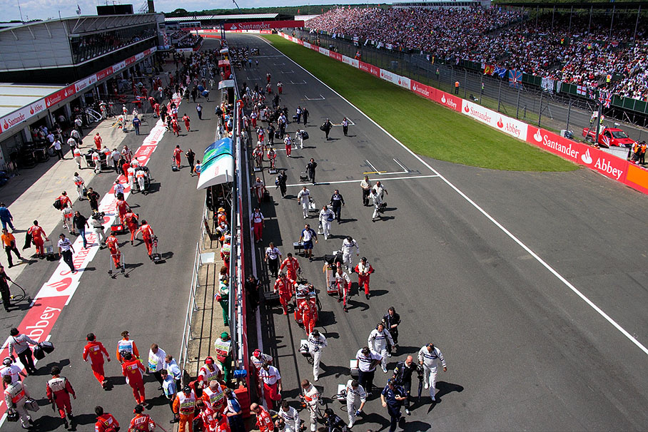Team crew and officials return to pits after cars launched to formation lap