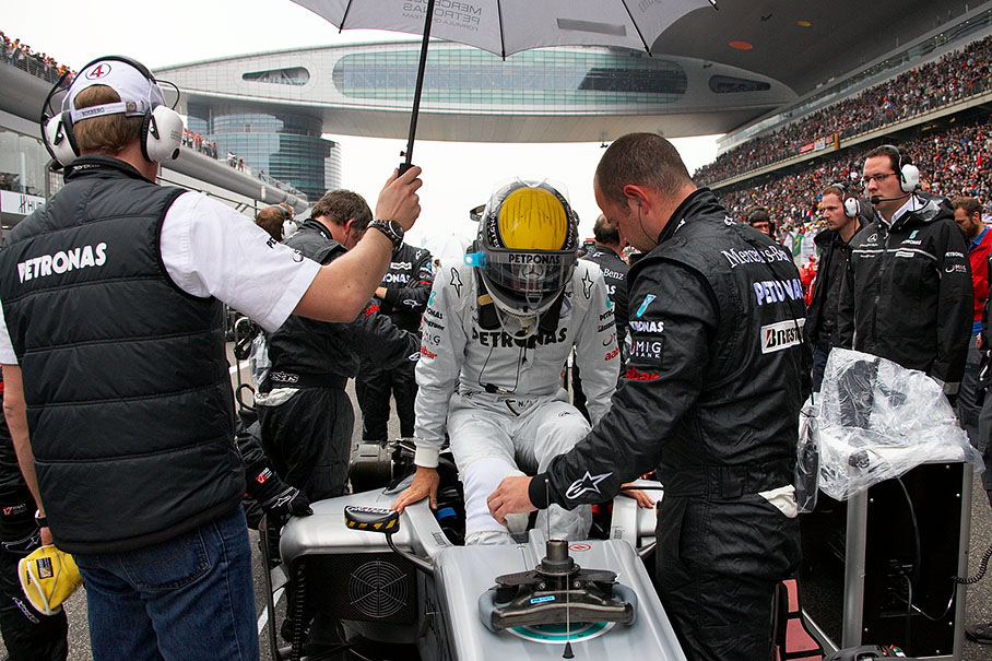 Nico Rosberg glides into the cockpit of his Mercedes car on fourth grid position