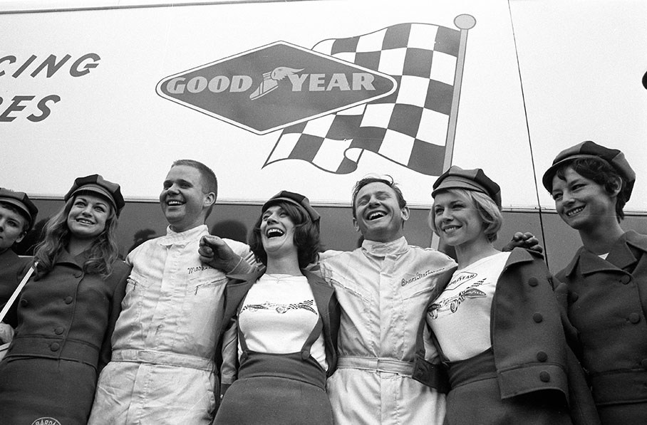 Mark Donohue and Bruce McLaren pose with advertising girls for their tyre sponsor Goodyear, 24h Le Mans 1967