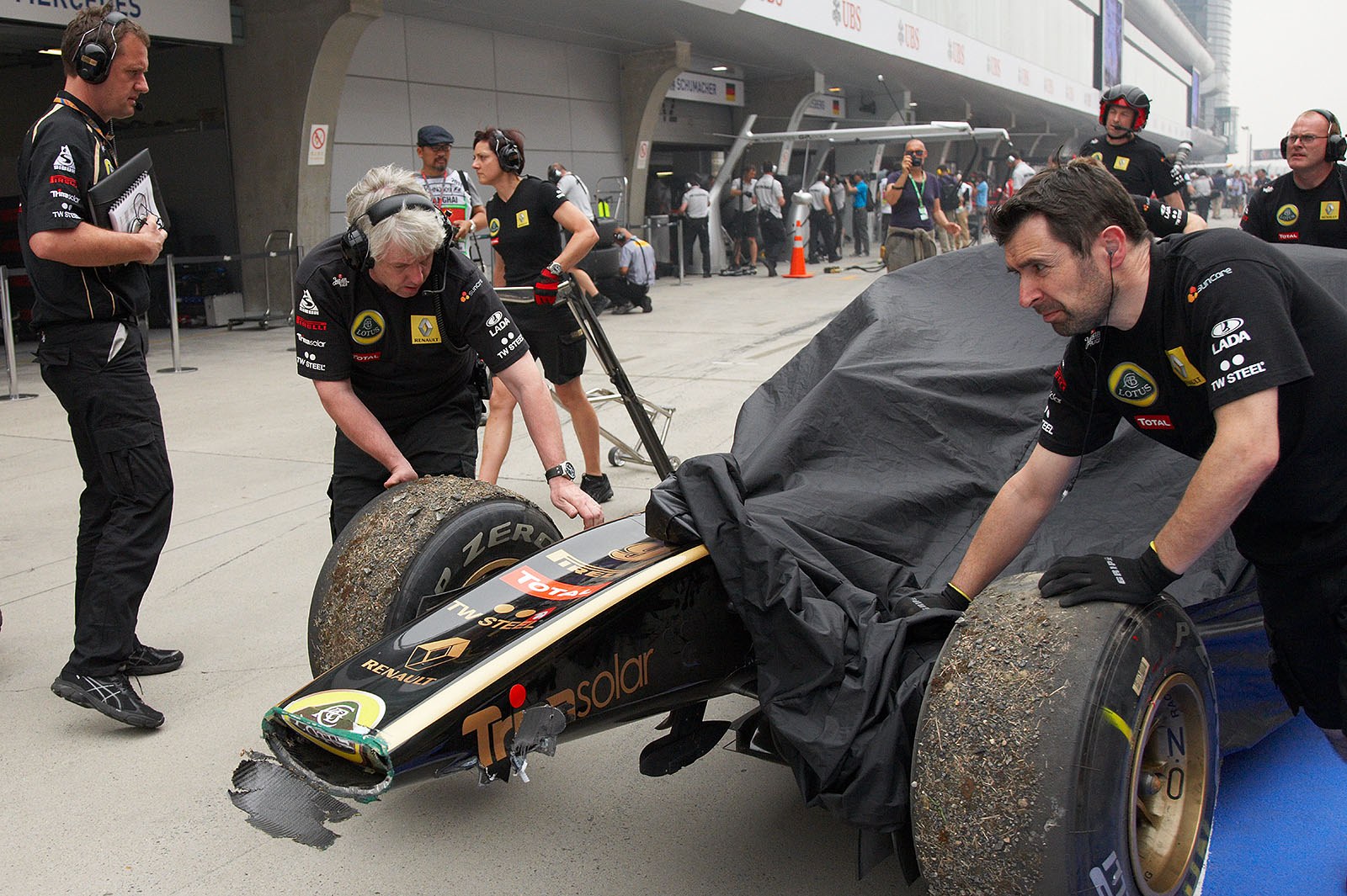Heidfeld's Lotus-Renault is returned to pits slightly messed up after a spin in practice