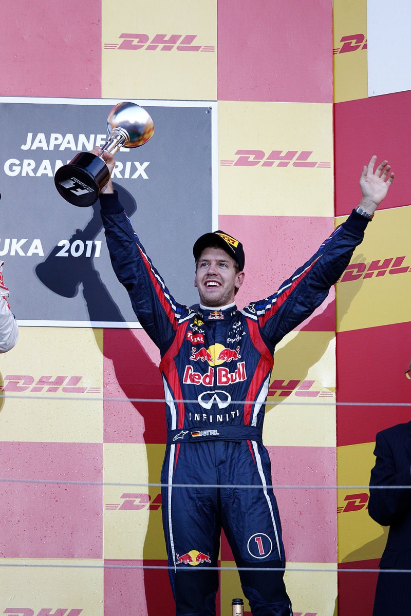 Third placed and newly crowned World Champion Sebastian Vettel of Red Bull Racing celebrates on podium and shakes his trophy towards the Japanese sky
