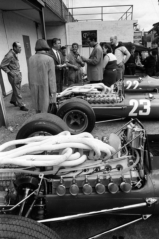 People do sightseeing at Ferrari pits, guided by chief engineer Mauro Forghieri