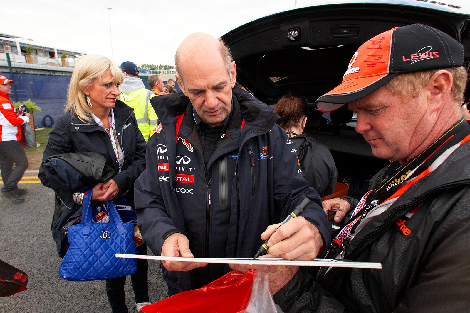 Red Bull technical director Adrian Newey signs autographs