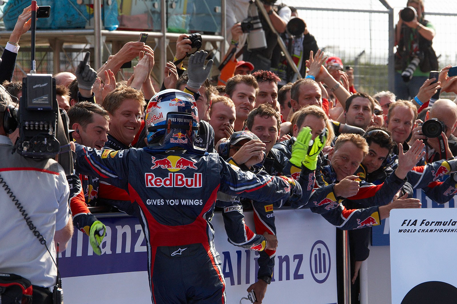 Race winner Sebastian Vettel celebrates in parc ferme, receiving congrats from the cheering Red Bull team