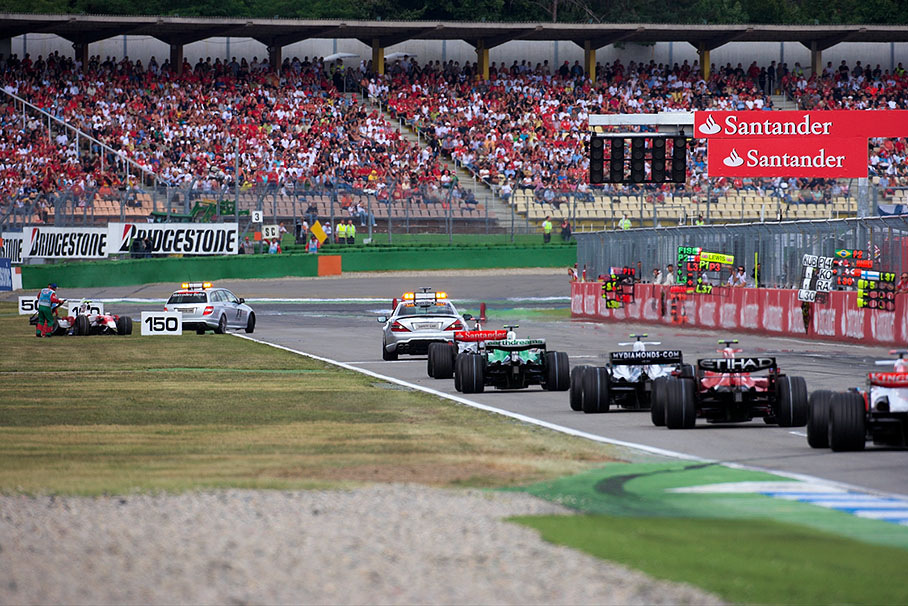 Glock seems to be safe and the medical car leaves the accident scene whilst the safety car leads the field between pitboards and a wreck