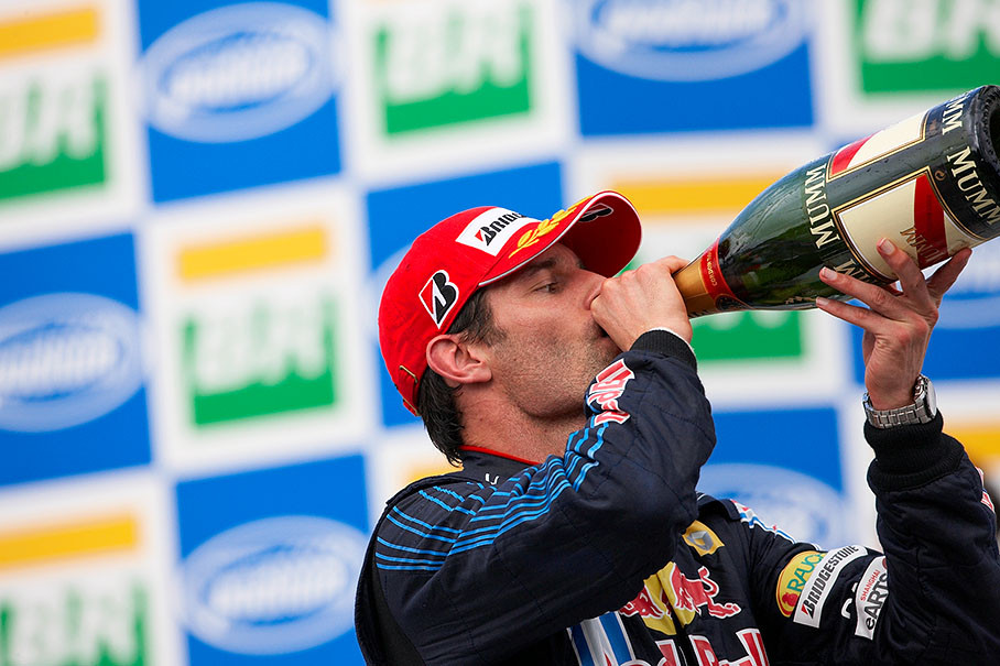 Mark Webber tries his winner's champagne