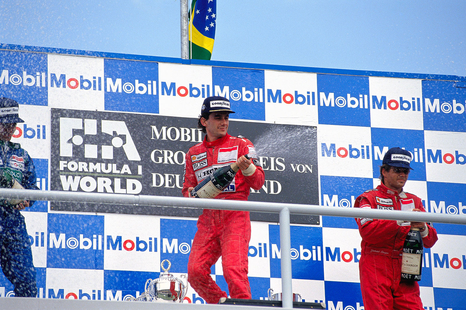 Race winner Ayrton Senna and third placed Gerhard Berger spray champagne on the podium after the German Grand Prix, 1990