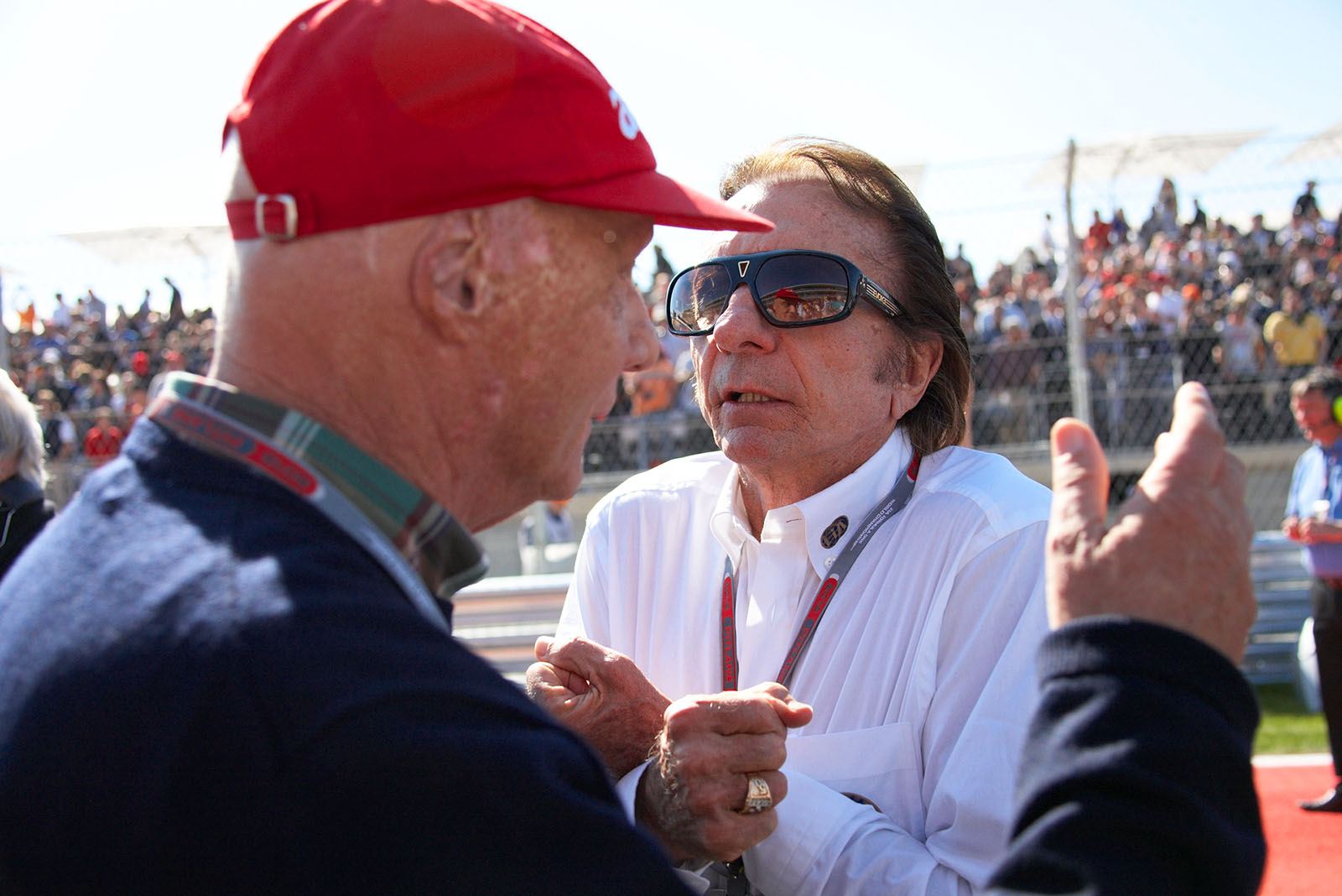Companions Emerson Fittipaldi and Niki Lauda discuss at the grid