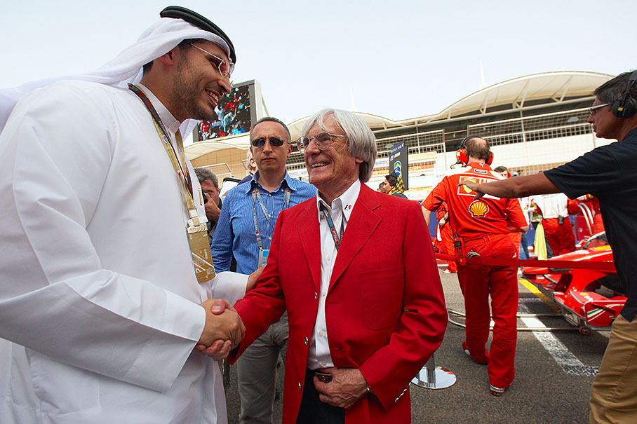 Bernie Ecclestone welcomes a VIP guest on the grid