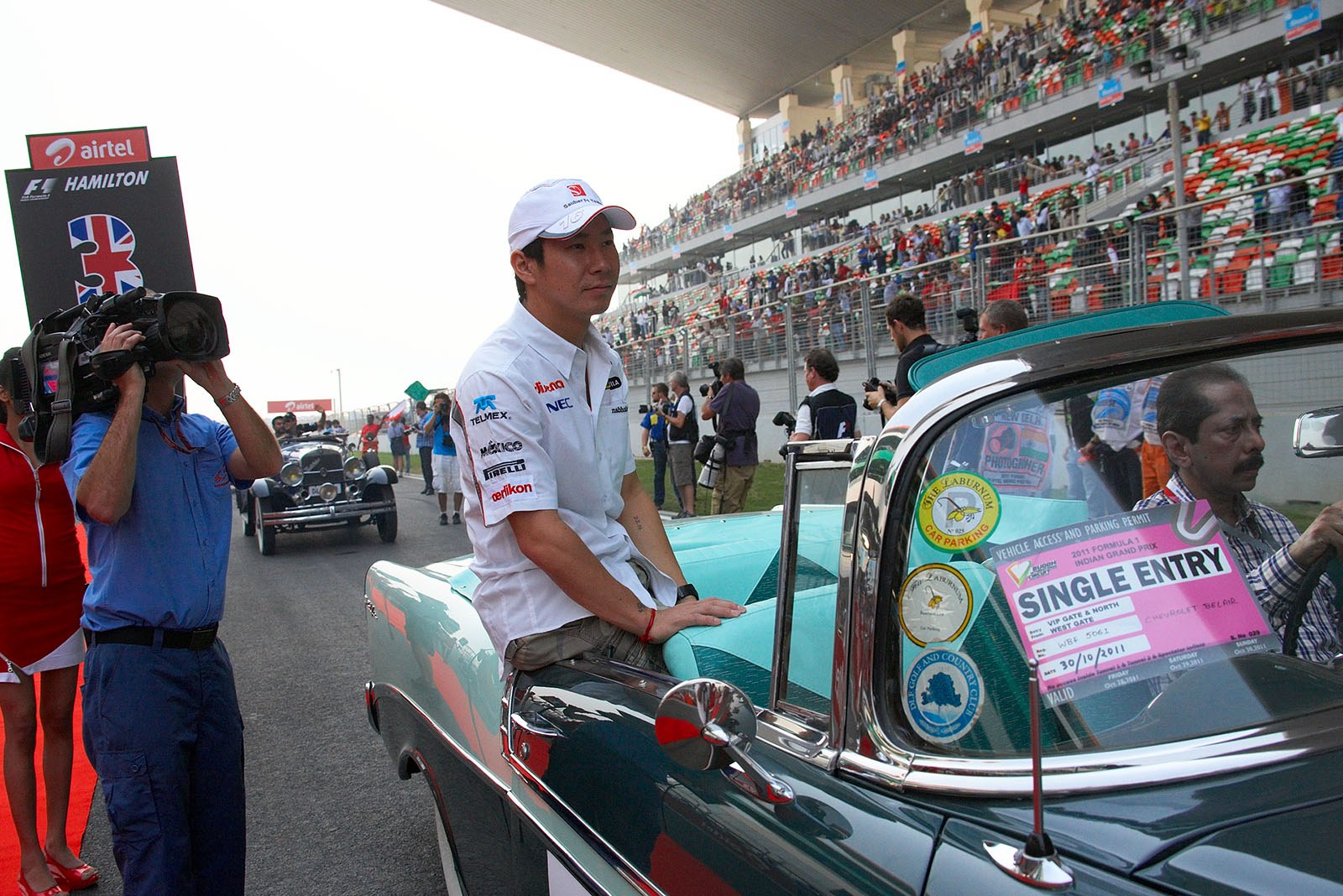 Kamui Kobayashi of the Sauber F1 Team rides a historic car for drivers parade