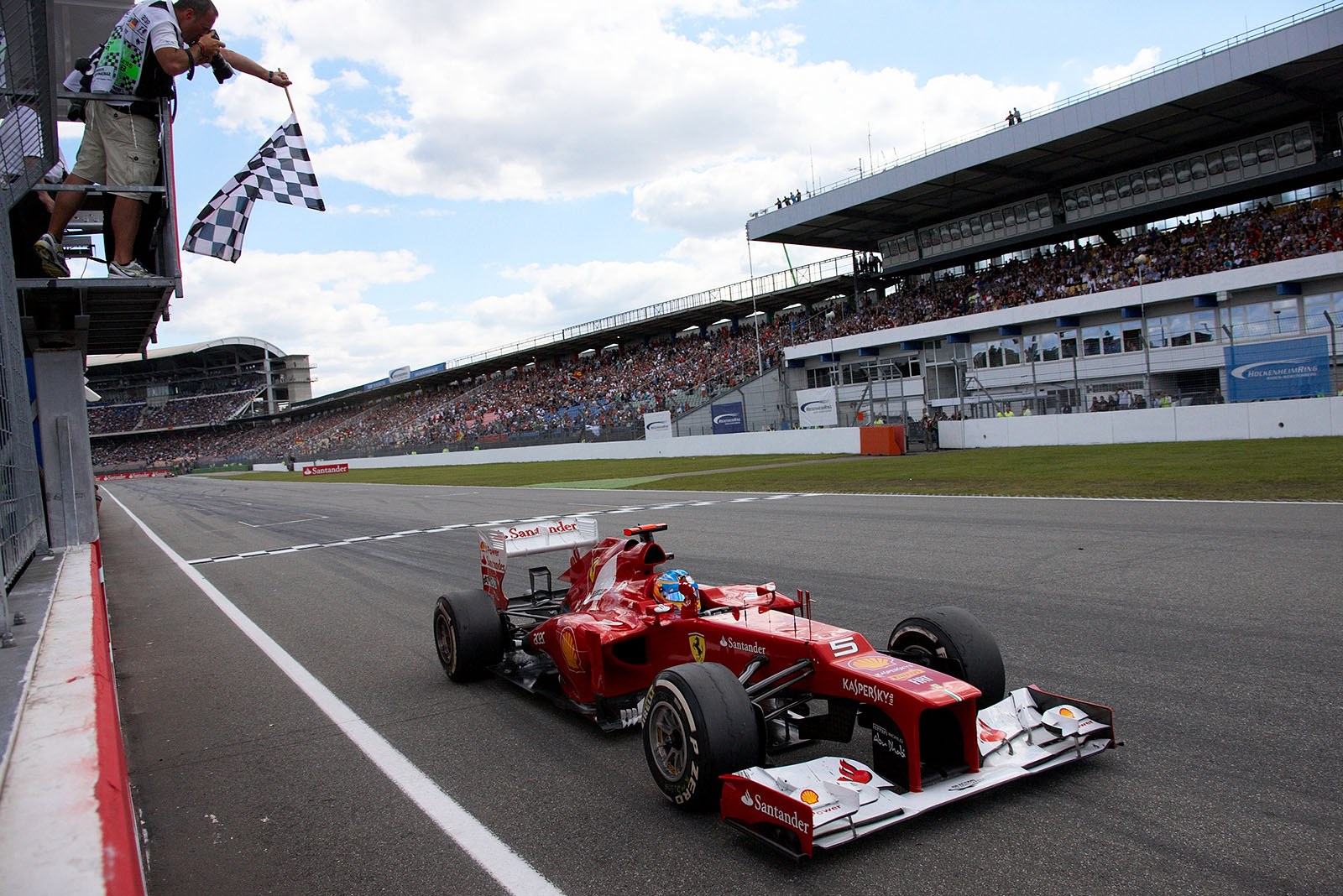 Fernando Alonso of Ferrari takes the chequered flag and wins the German Grand Prix in Hockenheim