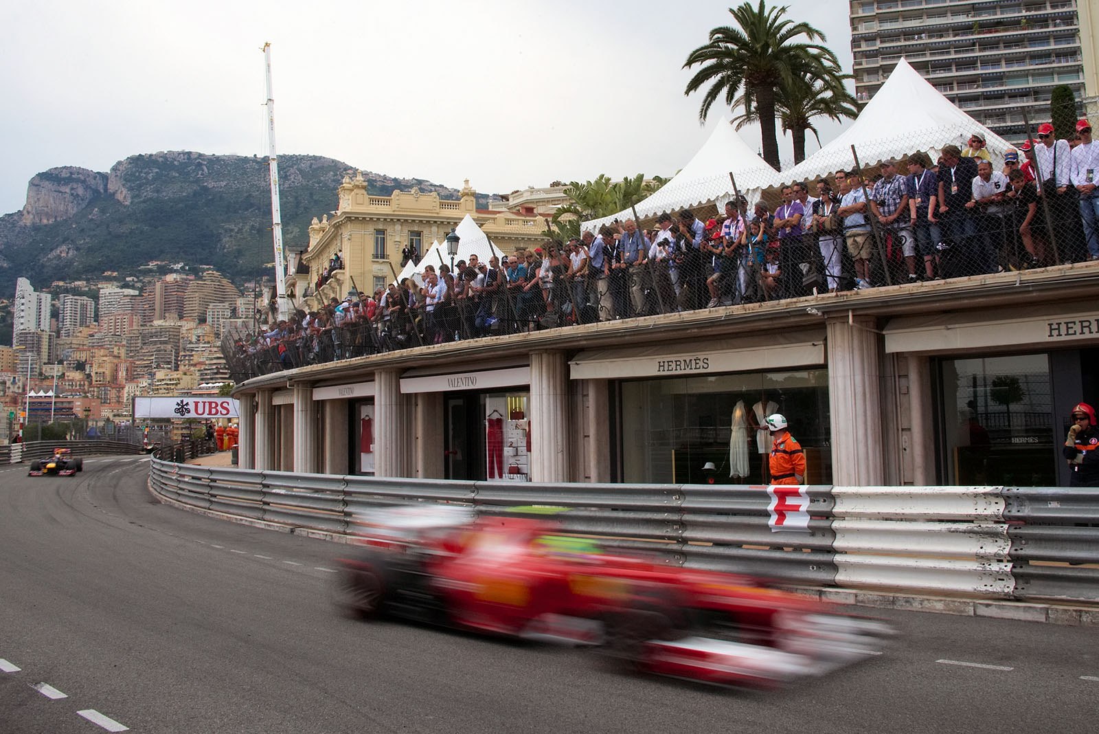 A speedy Ferrari passes the fashion shops