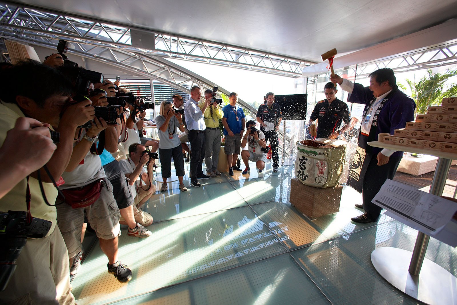 New Red Bull sponsor Hanshin Shuhan promotes their products in the Energy Station, test driver Sebastien Buemi beats the wooden sake barrel