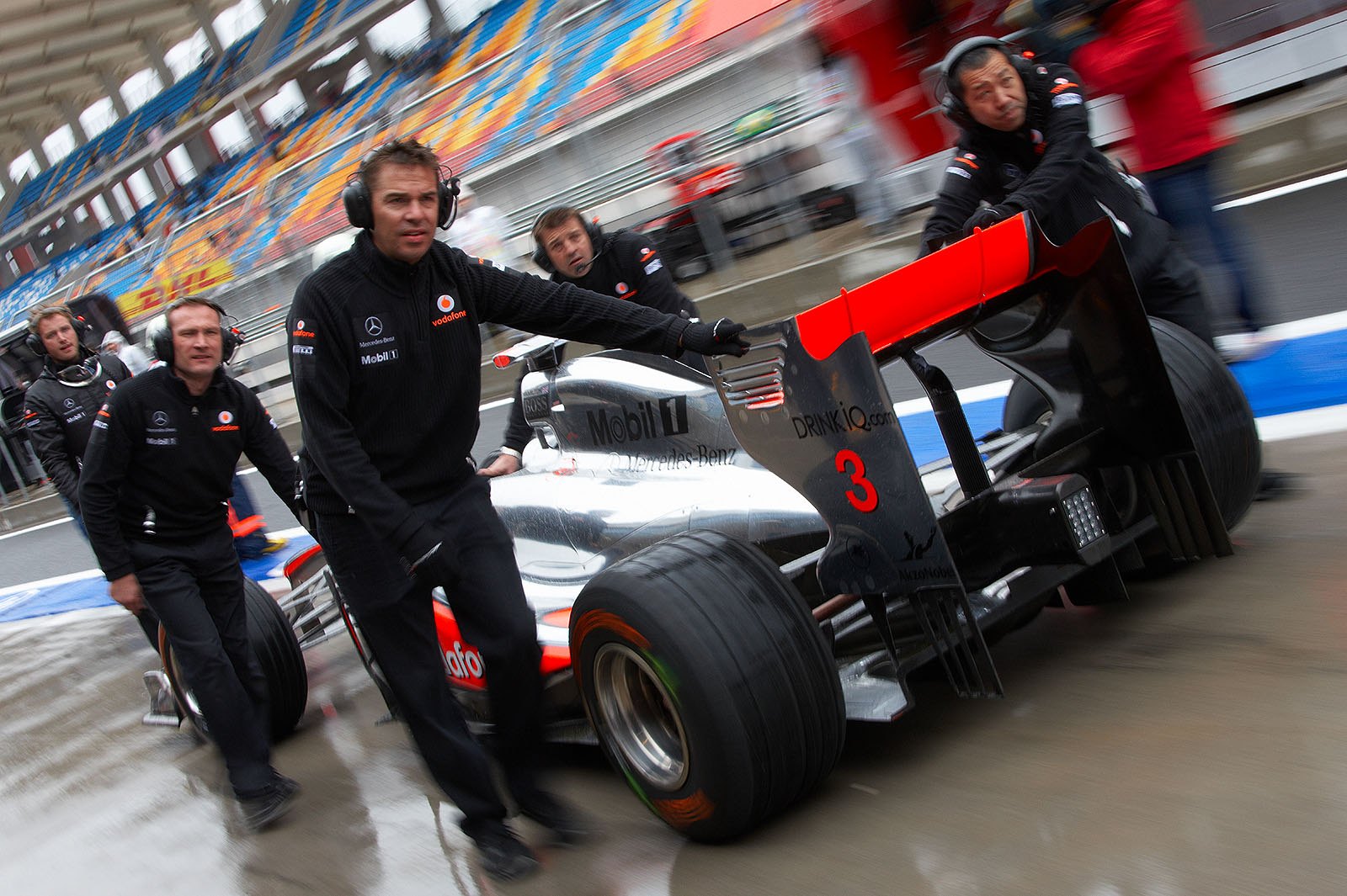 Lewis Hamilton's McLaren Mercedes is pushed back to pits as the session is stopped after Vettel's crash on Friday afternoon