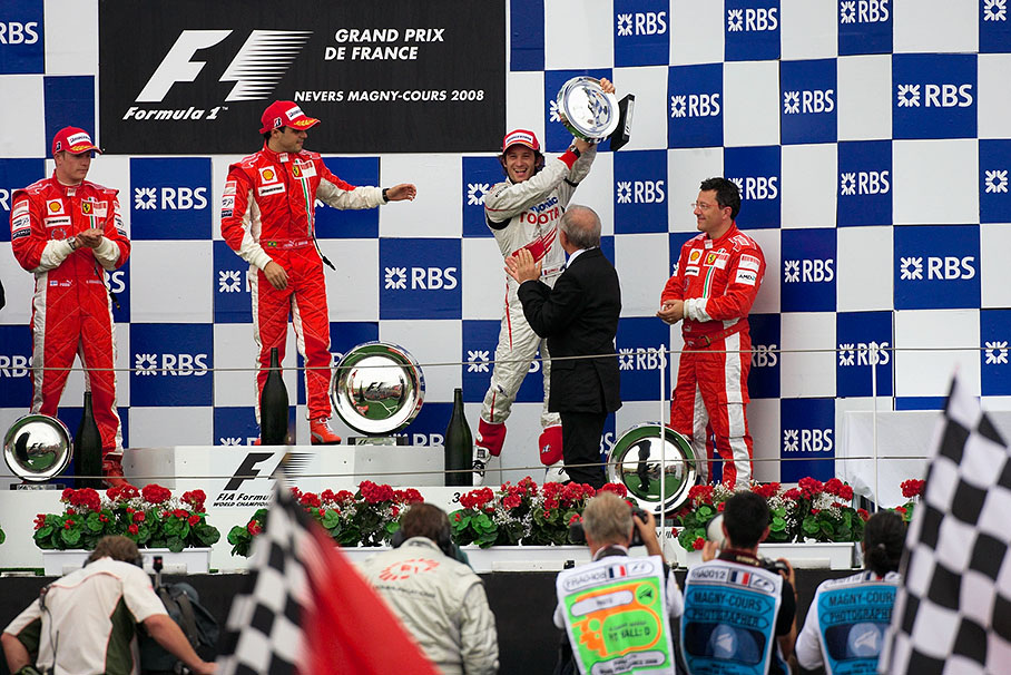 A highly delighted Trulli rises his trophy for the third place