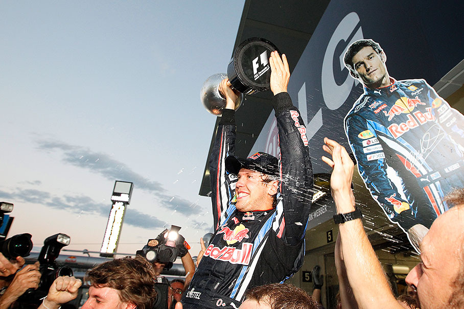 Red Bull's race winner Sebastian Vettel, back to realistic championship chances, presents his trophy after the Japanese GP 2010