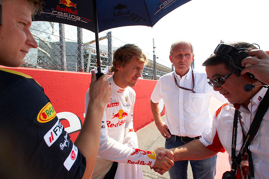 Under the eyes of Helmut Marko and Tommi Parmakoski, Sebastian Vettel of Red Bull shakes hands with Hirohide Hamashima, Head of Bridgestone Tyre Development
