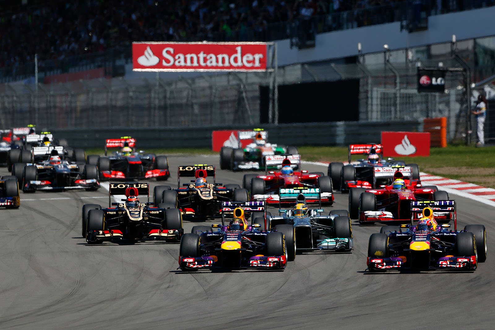 The start field approaches turn one, Vettel takes the lead from polesitter Hamilton and team mate Webber squeezes in between