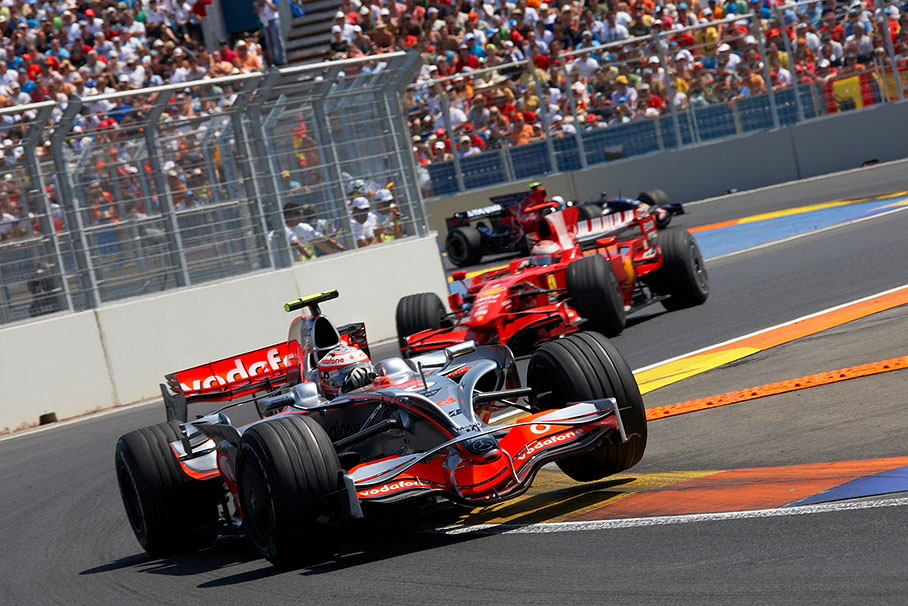 Kovalainen lifts a wheel in front of Raikkonen and Vettel
