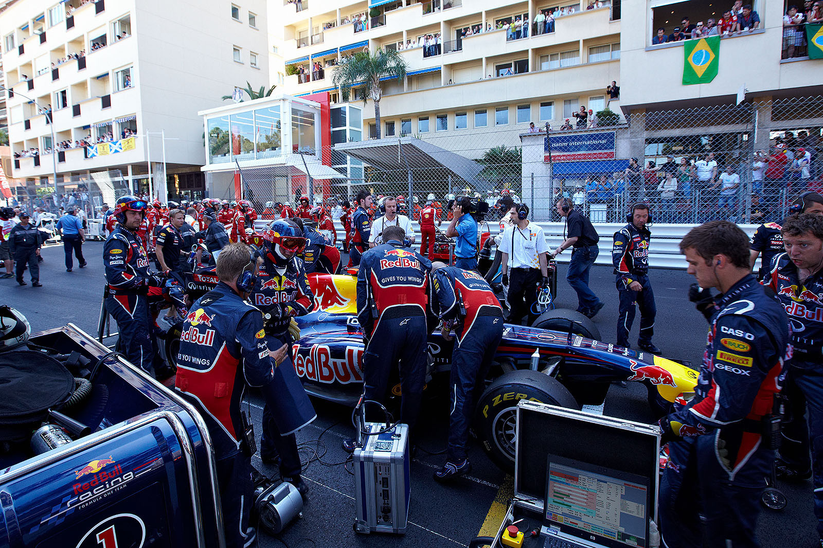 A crowded grid prepares for the restart of the race with 6 laps to go, Red Bull mechanics swirl around Vettel's car in the first row.