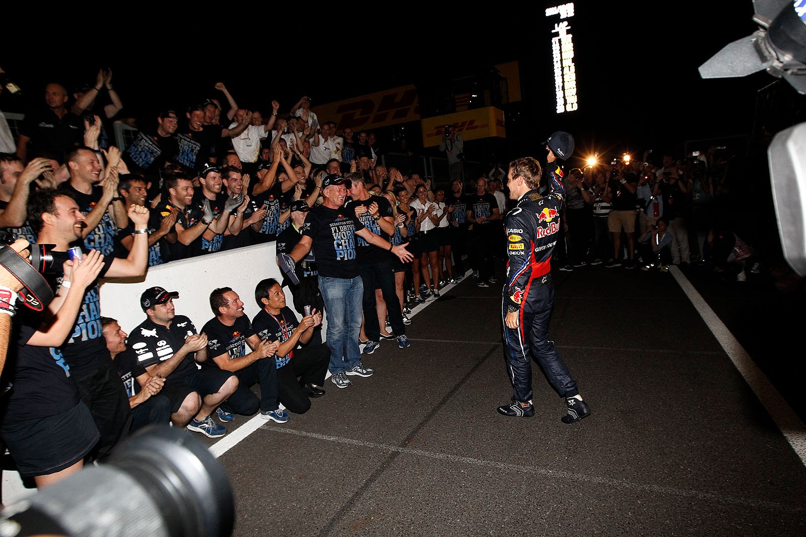 The newly crowned youngest double World Champion Sebastian Vettel comes to his waiting Red Bull Racing team to celebrate his achievement