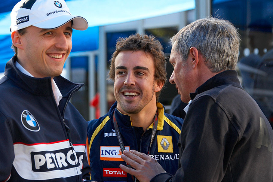 BMW Sauber driver Robert Kubica and Renaults Fernando Alonso chat with Kubicas manager Daniel Morelli