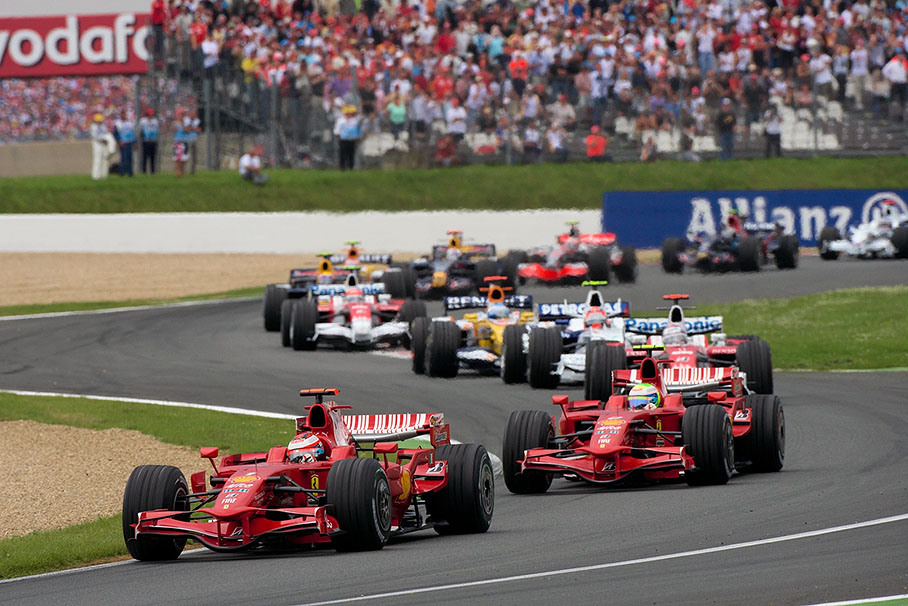 The start field flows through the first corner, both Ferraris in the lead with Raikkonen in front