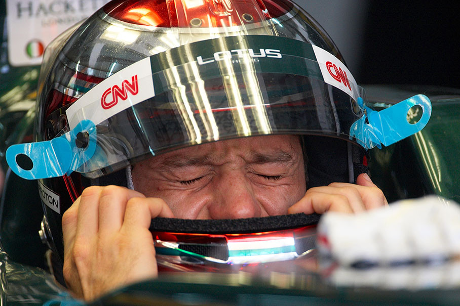 Jarno Trulli, Lotus Racing, squeezes his helmet on