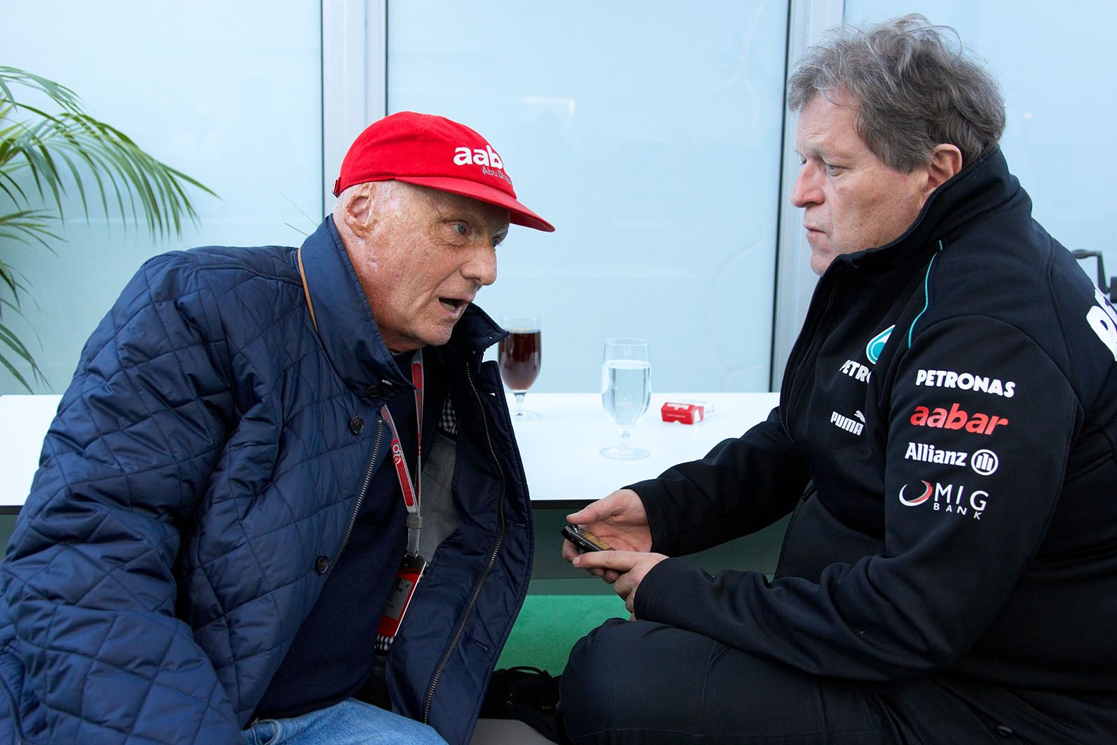 Niki Lauda speaks with Mercedes motorsport director Norbert Haug, his soon predecessor