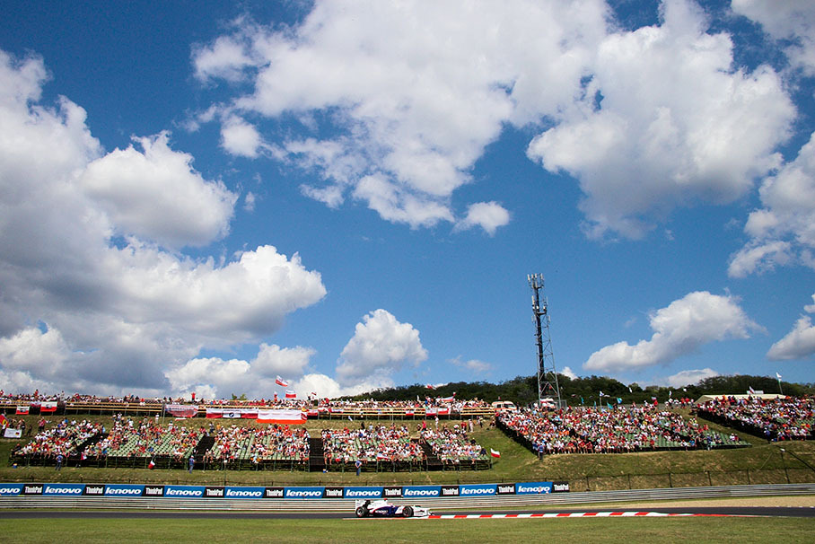 Blue sky and cotton balls above Kubica's BMW Sauber and his fans aside the track