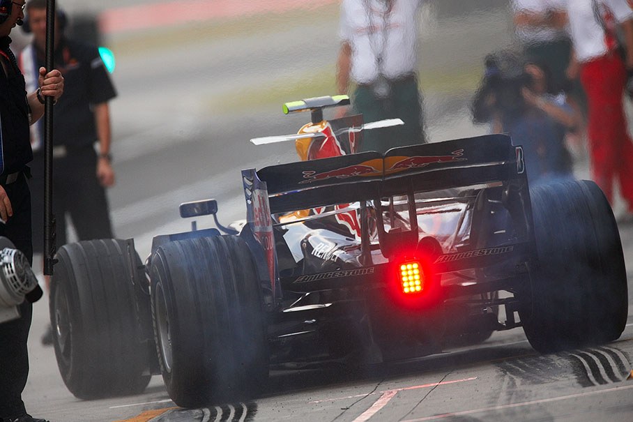 Mark Webber puts rubber on the pitlane at Red Bull pits