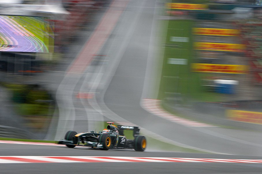 Jarno Trulli, Lotus Racing, climbs a wet chicane above Eau Rouge