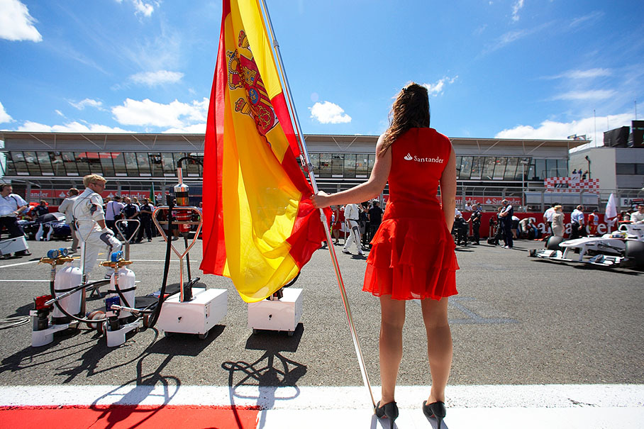 A grid girl holds the Spanish flag