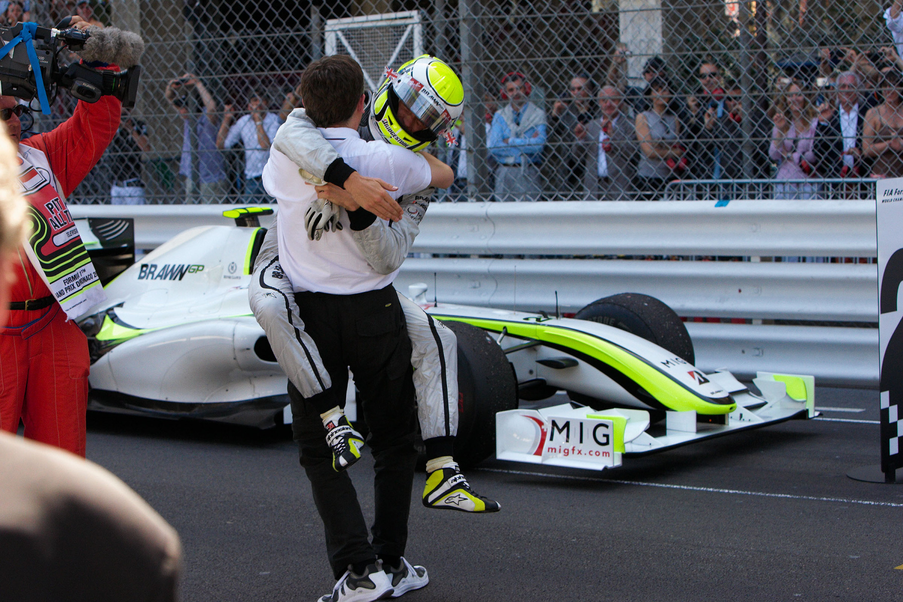 Brawn GP driver Jenson Button is delighted about winning the Monaco Grand Prix. Team manager Nick Fry hugs im in parc ferme