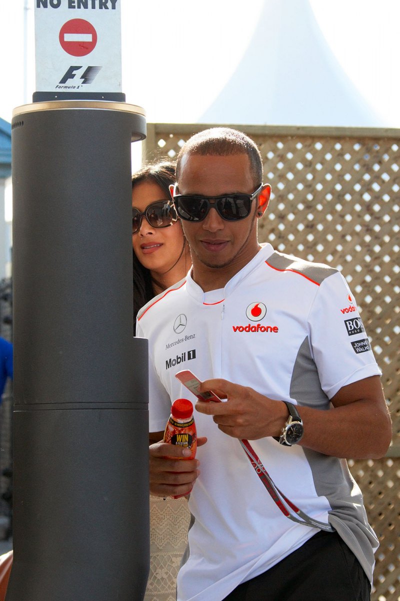 McLaren's Lewis Hamilton and his fiancee Nicole Scherzinger leave the paddock on Saturday afternoon