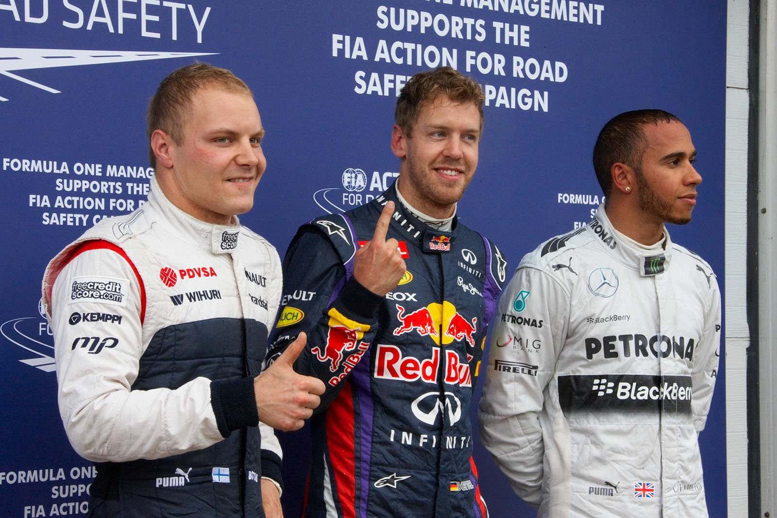 The fastest three qualifiers pose for the world's media: Red Bull race driver Sebastian Vettel as polesetter in the middle with third qualified Williams driver Valtteri Bottas and Lewis Hamilton of Mercedes as second on the grid