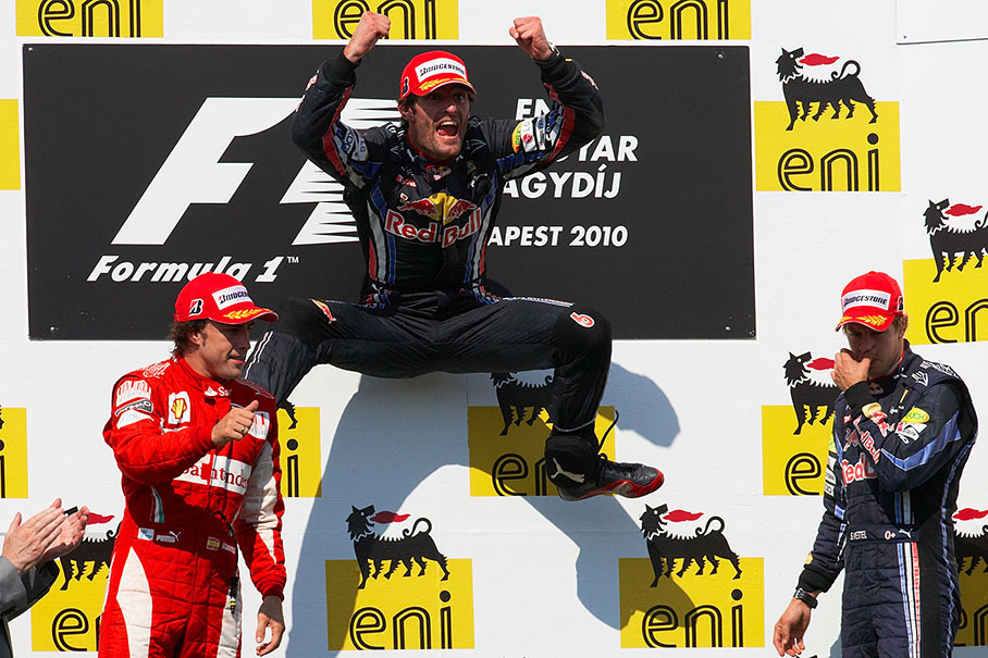 Red Bull's Mark Webber jumps on the podium after winning the Hungarian GP
