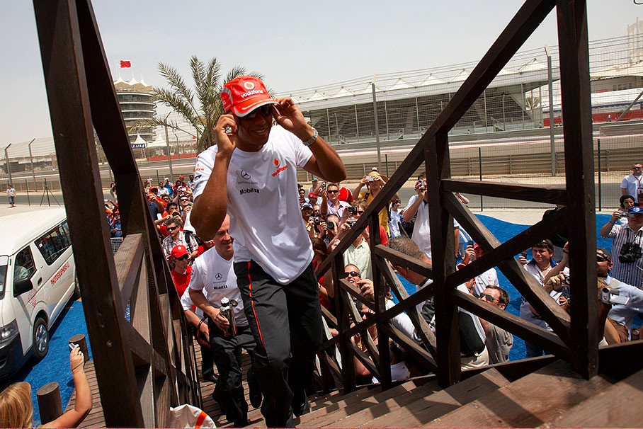 Lewis Hamilton climbs the stairs up to the autograph area