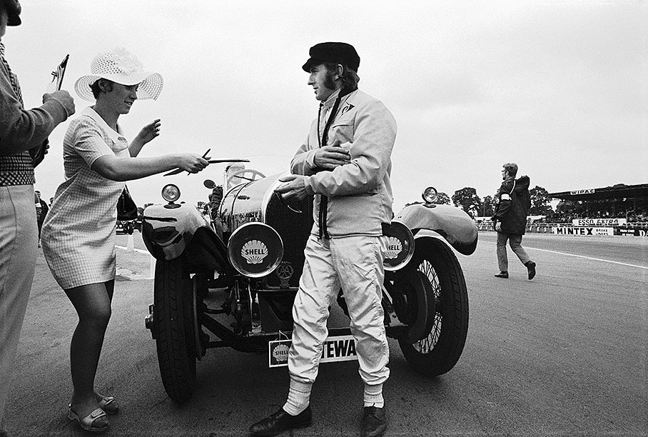 British Grand Prix at Silverstone 1969: Jackie Stewart gives an autograph to a fan after the drivers parade