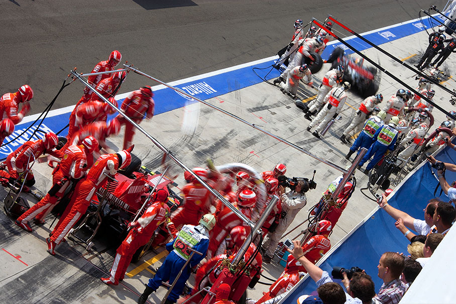 Race leader Hamilton pits out before chaser Raikkonen has finished his service stop